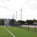 Jaypro Sports FieldPro Soccer Net System FNSB-65 behind soccer goals, keeping balls in play area