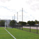 Jaypro Sports FieldPro Soccer Net System FNSB-65 behind soccer goals, keeping balls in play area