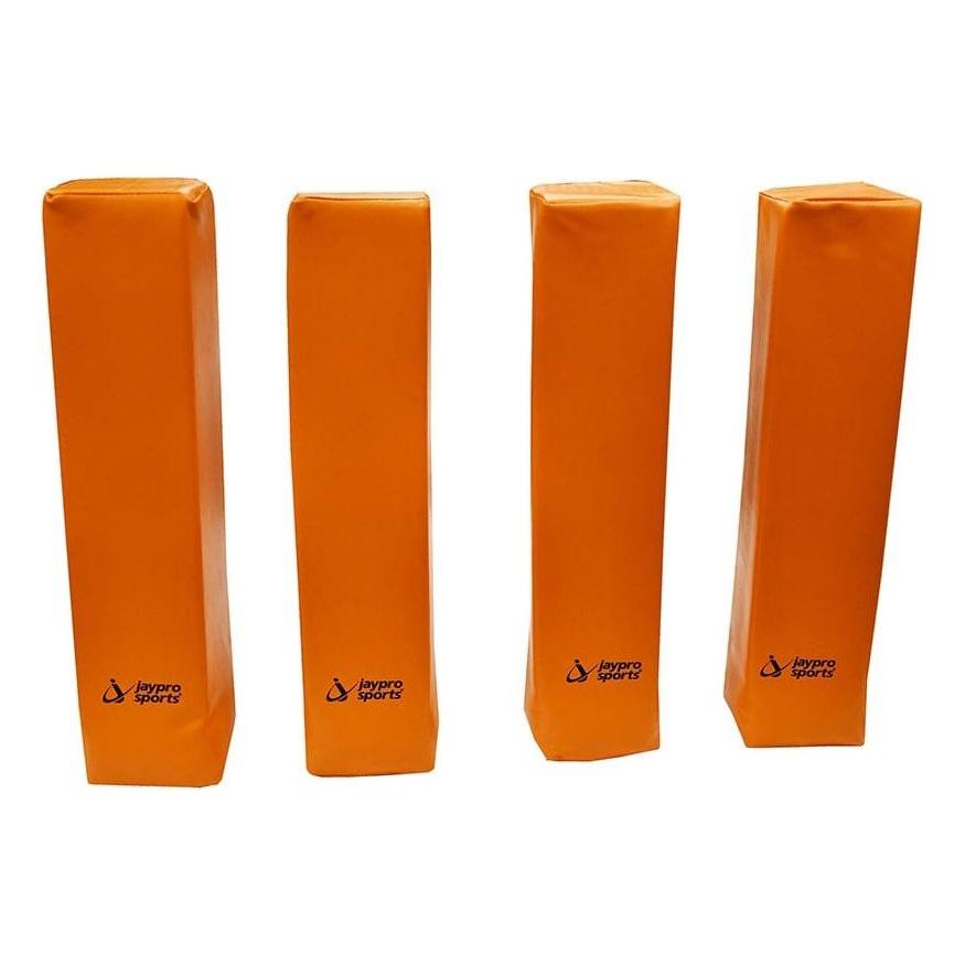 Four orange free-standing football field markers set up on a grass field